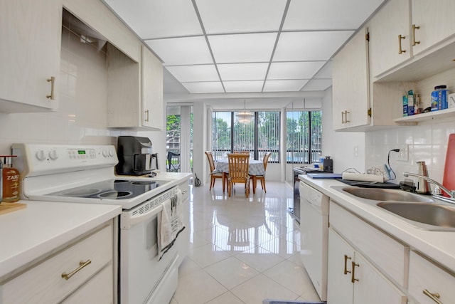 kitchen with sink, white appliances, decorative backsplash, and light tile patterned flooring