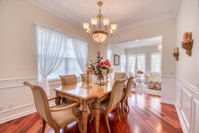 dining area with dark hardwood / wood-style flooring, crown molding, and a chandelier