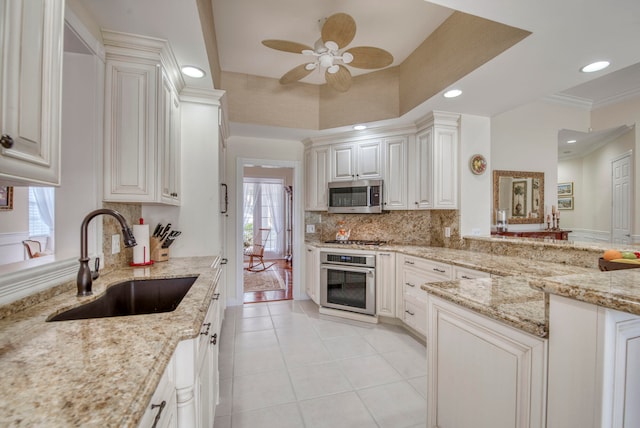 kitchen with light stone countertops, white cabinetry, sink, and appliances with stainless steel finishes