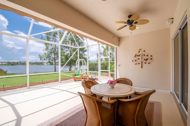 sunroom featuring ceiling fan and a water view