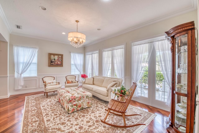 living room with wood-type flooring, an inviting chandelier, and a wealth of natural light