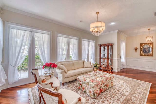 living room featuring dark hardwood / wood-style floors, crown molding, and a notable chandelier