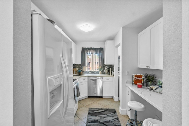 bathroom with tile patterned flooring, backsplash, sink, and a textured ceiling