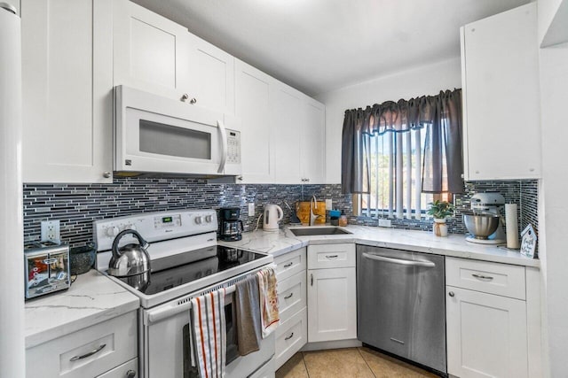 kitchen featuring white appliances, decorative backsplash, white cabinetry, and sink