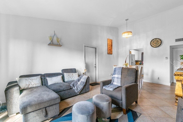 tiled living room featuring a high ceiling and a chandelier