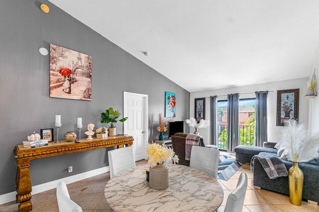 dining room featuring tile patterned flooring, vaulted ceiling, and baseboards