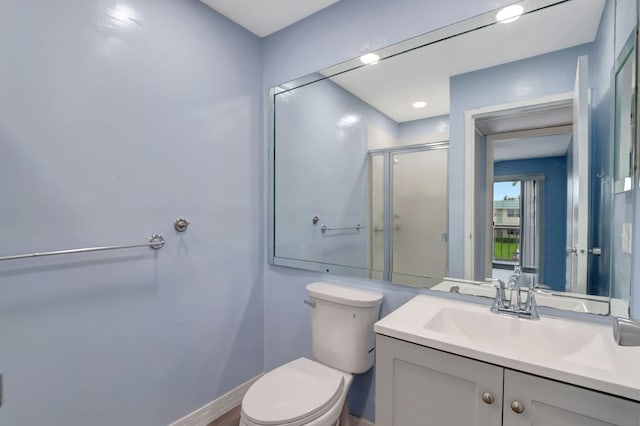 bathroom featuring vanity, toilet, and an enclosed shower