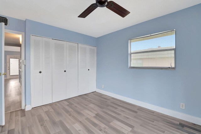 unfurnished bedroom with light hardwood / wood-style floors, ceiling fan, and a closet