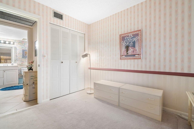 carpeted bedroom featuring a closet and ensuite bath