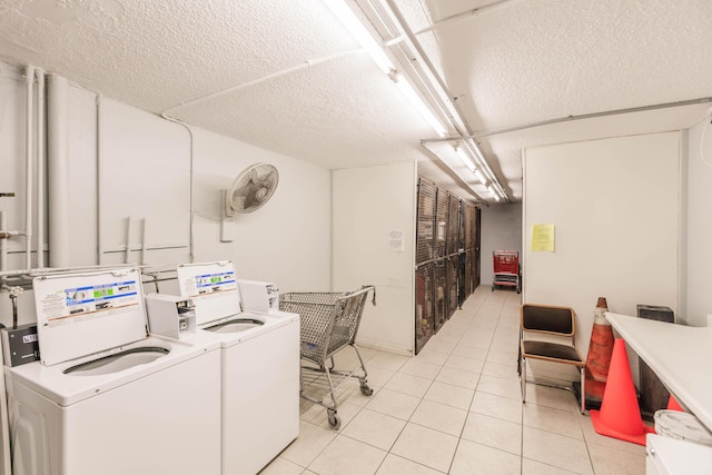 laundry room with washer and dryer, light tile patterned flooring, and a textured ceiling