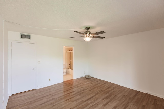 unfurnished room with a textured ceiling, ceiling fan, and hardwood / wood-style floors