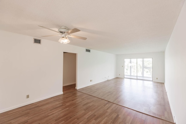 unfurnished room with wood-type flooring, a textured ceiling, and ceiling fan