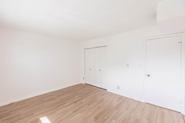 unfurnished bedroom with a closet and light hardwood / wood-style floors