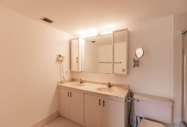 bathroom featuring vanity, tile patterned floors, and toilet