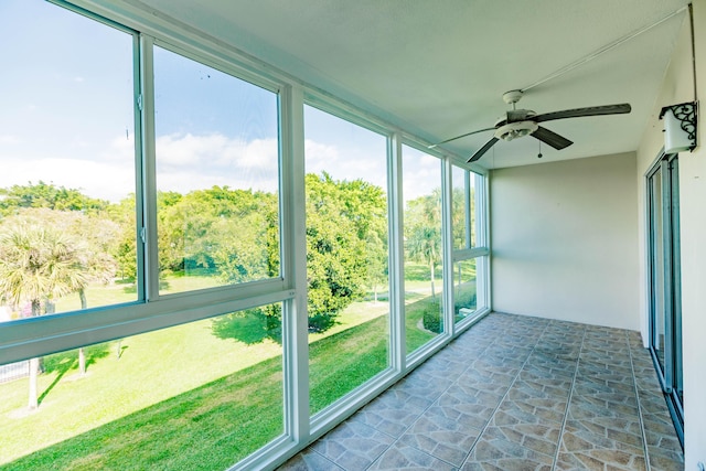 unfurnished sunroom with ceiling fan