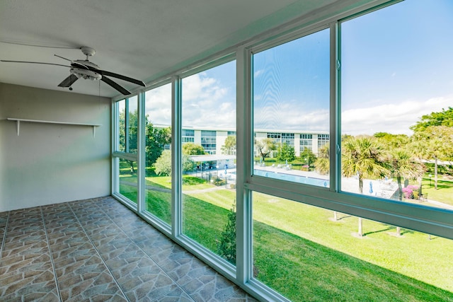 unfurnished sunroom featuring ceiling fan