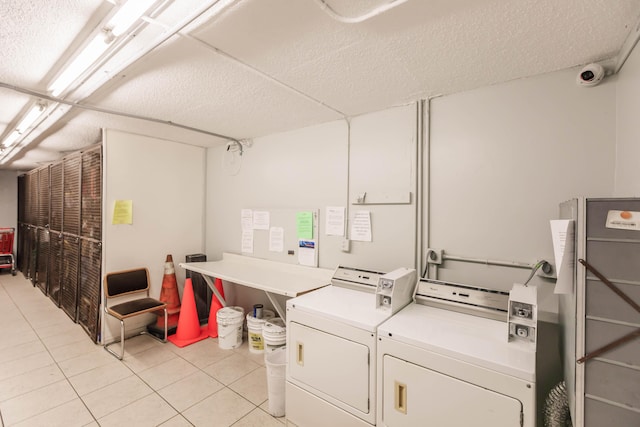 clothes washing area with washer and dryer and light tile patterned floors