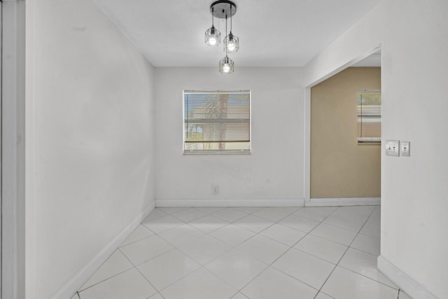 tiled spare room featuring plenty of natural light