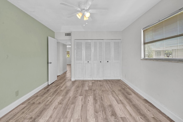 unfurnished bedroom with ceiling fan, a closet, and light wood-type flooring