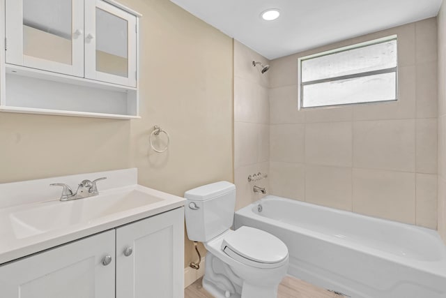 full bathroom with vanity, toilet, hardwood / wood-style floors, and tiled shower / bath