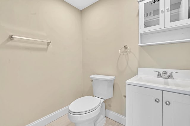 bathroom with hardwood / wood-style floors, toilet, and vanity