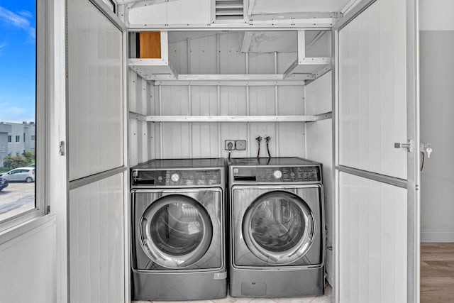 laundry area with washer and clothes dryer and wood-type flooring