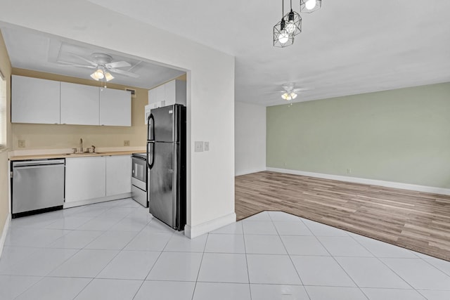 kitchen with white cabinets, light hardwood / wood-style flooring, stainless steel appliances, and ceiling fan