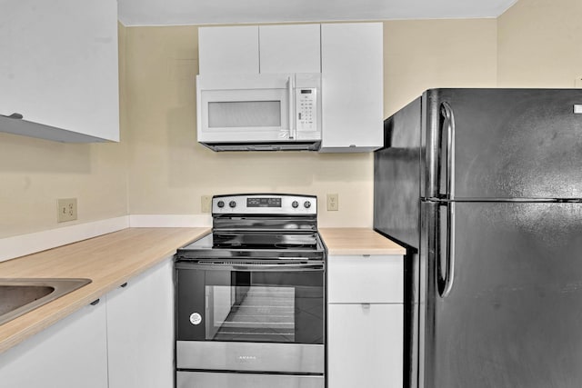 kitchen featuring black refrigerator, sink, stainless steel electric range, and white cabinetry