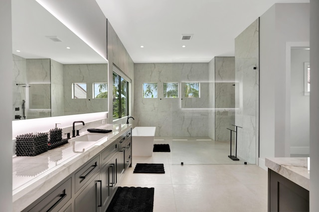 full bath with vanity, a marble finish shower, tile patterned flooring, and a soaking tub