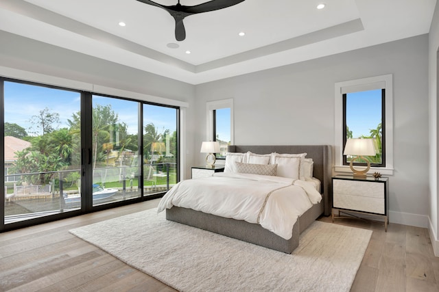 bedroom with ceiling fan, multiple windows, and light hardwood / wood-style floors