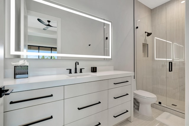 bathroom featuring tile patterned flooring, toilet, a shower with door, and vanity