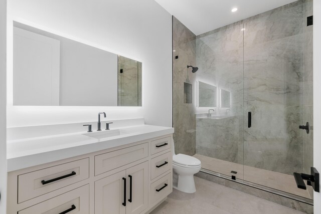 bathroom featuring vanity, toilet, and walk in shower