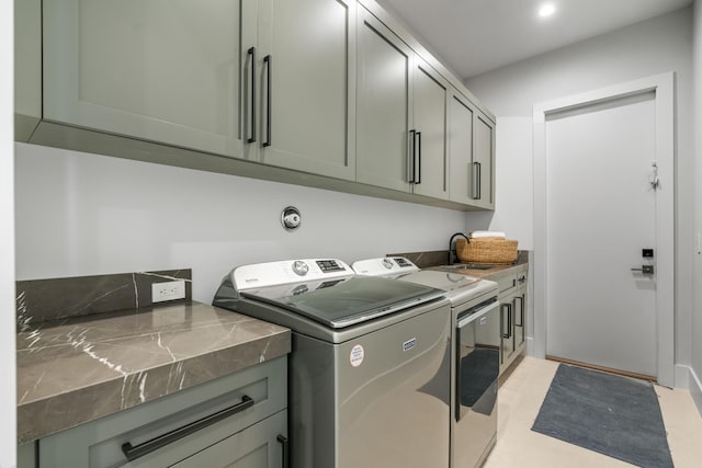 clothes washing area with cabinets, separate washer and dryer, and sink