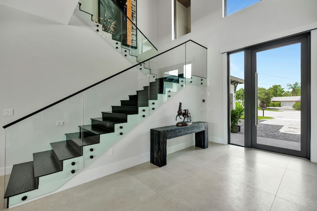 stairway featuring a towering ceiling