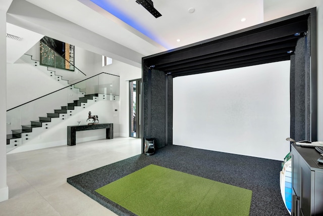 recreation room featuring finished concrete flooring and golf simulator