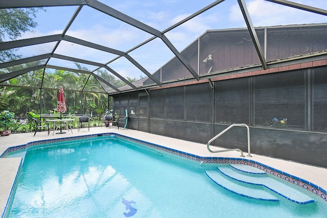 view of pool with glass enclosure and a patio