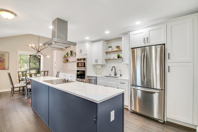 kitchen featuring hardwood / wood-style floors, sink, appliances with stainless steel finishes, island exhaust hood, and pendant lighting