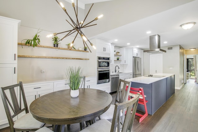 dining area with a chandelier, wood finished floors, visible vents, and recessed lighting