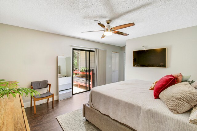 bedroom featuring ceiling fan, a textured ceiling, dark hardwood / wood-style flooring, and access to exterior