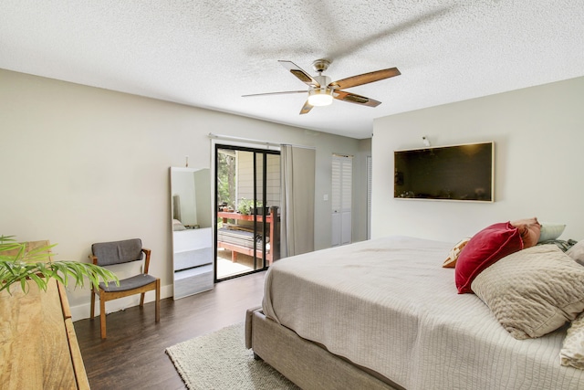 bedroom featuring dark wood-style floors, access to outside, baseboards, and a textured ceiling