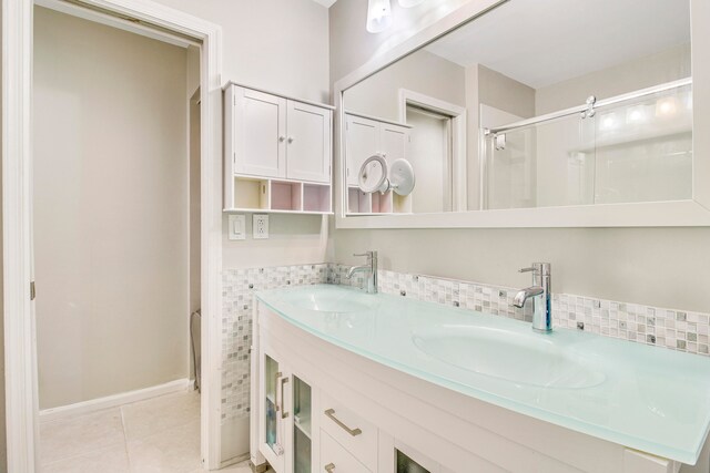 bathroom with tile patterned flooring, an enclosed shower, and vanity