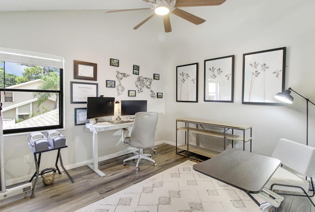 office featuring light wood-style floors, ceiling fan, baseboards, and vaulted ceiling