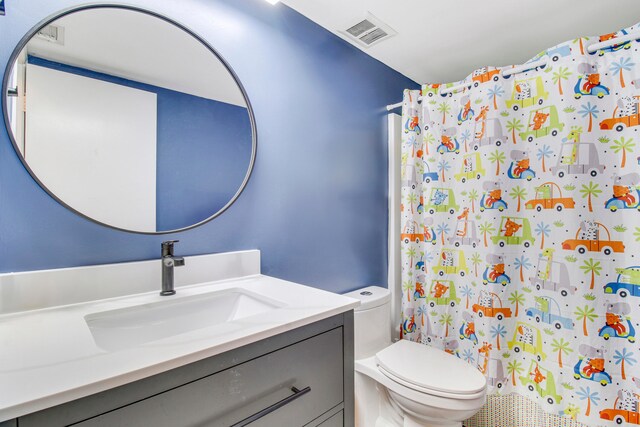 bathroom featuring vanity, walk in shower, and toilet