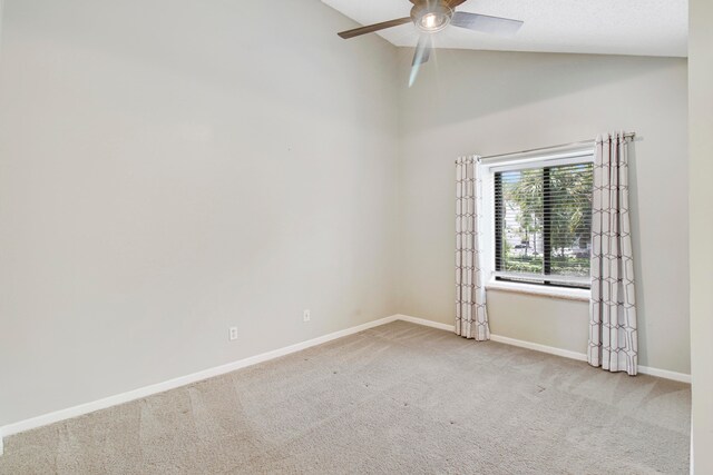 empty room with high vaulted ceiling, ceiling fan, and light colored carpet