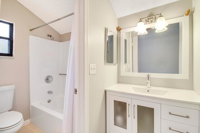 full bathroom with shower / bath combination with curtain, vaulted ceiling, a textured ceiling, vanity, and toilet