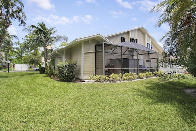 back of property featuring a lanai and a yard