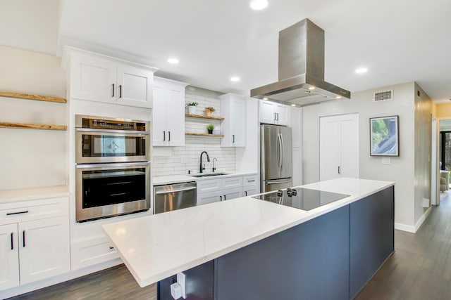 kitchen with backsplash, stainless steel appliances, island range hood, and dark hardwood / wood-style flooring