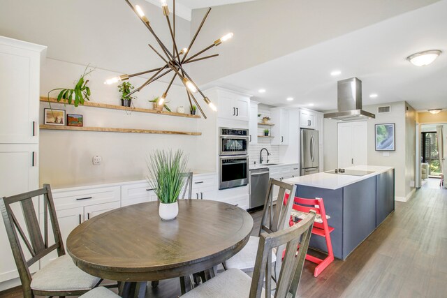 dining room with sink, a chandelier, and light wood-type flooring