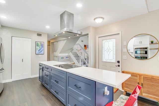 kitchen with black electric cooktop, dark wood-type flooring, island range hood, and stainless steel oven