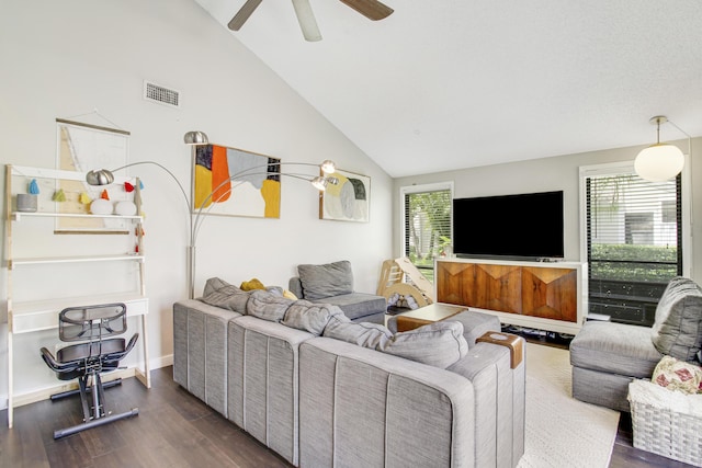 living room with dark wood-type flooring, visible vents, ceiling fan, and high vaulted ceiling